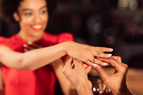 Unbekannter Mann legt Verlobungsring an Frauenhand - Foto, Bild