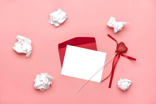 roter Umschlag, weißes Briefpapier, Amor, Herzen, Stift, zerknülltes Papier auf rosa Hintergrund glückliches Valentinstagskonzept, Liebeserklärung von oben, flache Laienkarte Kopierplatz-Attrappe - Foto, Bild