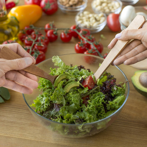 Blisko kobiety ręce mieszając smaczne sałatki wegetariańskie - Zdjęcie, obraz