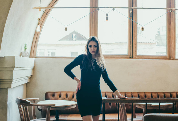 Красивая элегантная брюнетка в черном платье расслабляется в уличном кафе. Реклама, мода. Тонированное фото
 - Фото, изображение