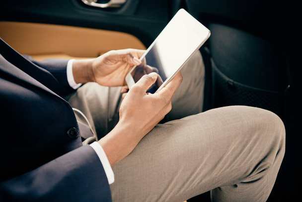 Primer plano de un hombre trabajando en su tableta en el coche
. - Foto, imagen
