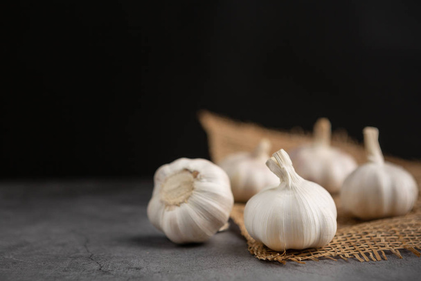 Garlic on the black cement floor and black background. - Photo, Image