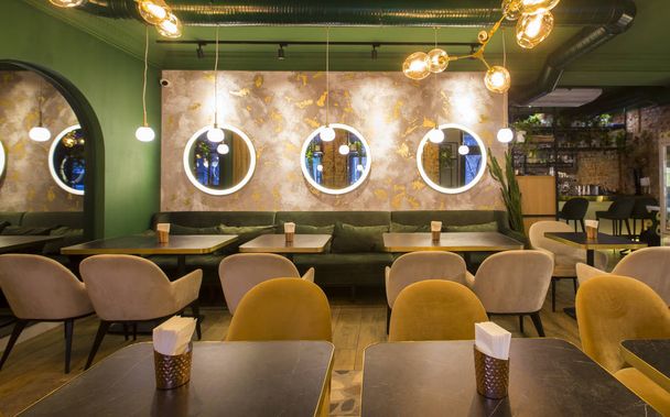 テーブルとソファ付きのモダンなレストランのインテリア、明るい緑の壁 - 写真・画像