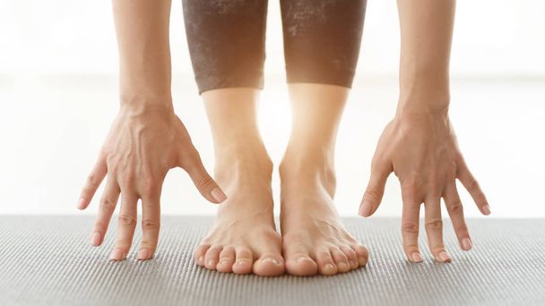 Mani e gambe della donna che si esercita sul tappetino yoga
 - Foto, immagini