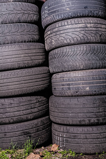 A lot of used out car tires in tire fitting. Stock photo many tires. - Photo, Image