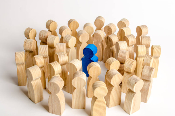 The blue figure of the leader is surrounded by a crowd of people. Leadership and team management, an example for imitation. Loyalty and trust. Idol. Like-minded people and followers - Foto, afbeelding