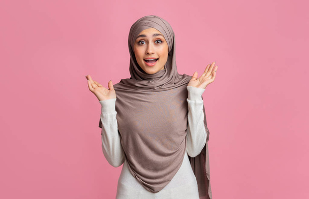 Surprised muslim girl in hijab reising hands in amazement - 写真・画像