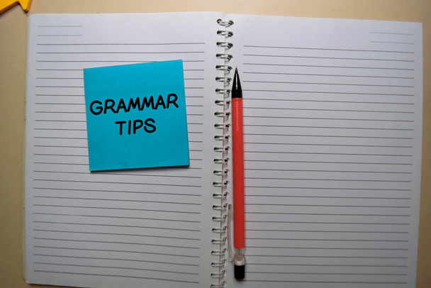 Consejos de gramática escribir en una nota pegajosa aislado en el escritorio de la oficina
. - Foto, imagen