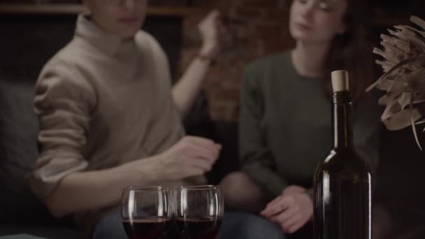 Man pouring wine in glasses and gives to woman, shallow depth of field, slow motion - Video