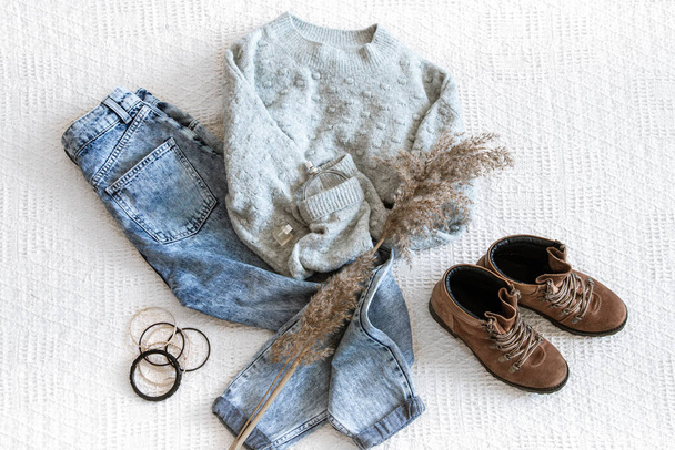 Набор с модной женской одеждой джинсы и свитер
 . - Фото, изображение