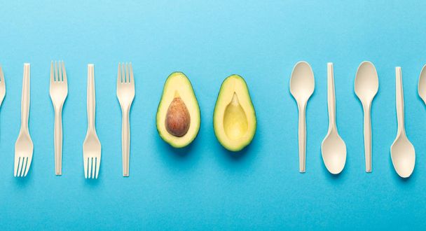 Disposable tableware of avocado seed, blue background - Photo, Image