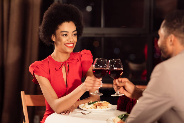 Joyeux couple afro-américain d'amoureux clinking lunettes dans le restaurant
 - Photo, image