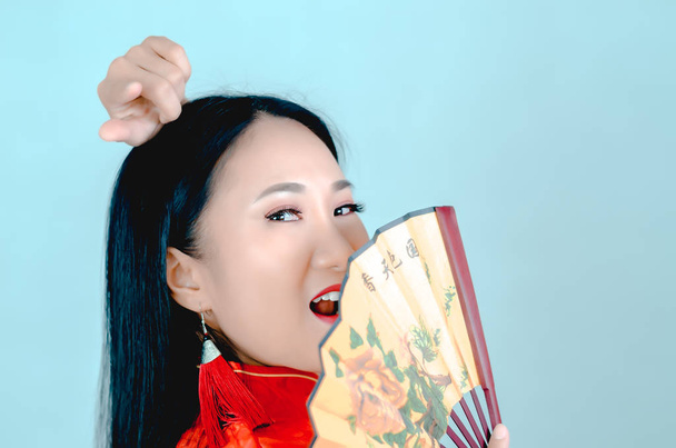 Mulher asiática bonita em um vestido vermelho segurando um ventilador na mão com as palavras de fortuna e felicidade no Ano Novo Chinês 2020, isolado em um fundo branco
. - Foto, Imagem