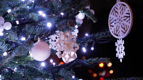 Versierde nieuwjaarsboom achtergrond. Kerstvakantie speelgoed met fonkelende lichten op groene kerstboom close-up. - Video