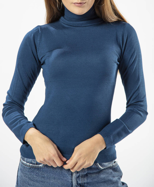 girl in a blue wool turtleneck and blue jeans on a white background, female blue wool sweater close-up - Foto, Imagen