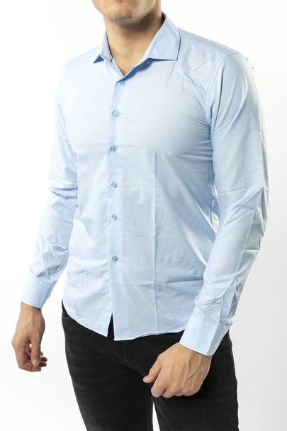 a man in a light blue shirt and black jeans on a white background, a man's shirt close-up - Foto, Bild