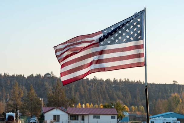 Coucher de soleil passe à travers un drapeau américain agitant près de Terrebonne
 - Photo, image