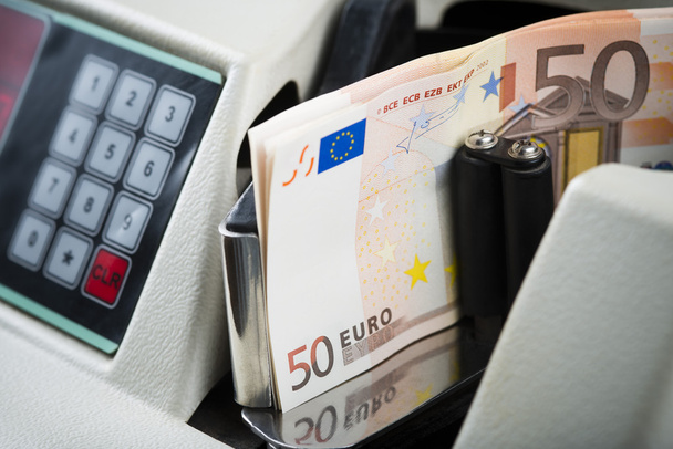 Cinquenta notas de euro contadas numa máquina
 - Foto, Imagem