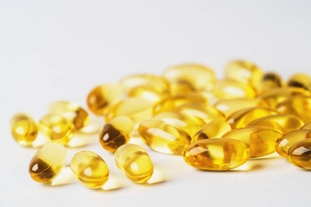 Omega 3 píldoras amarillas sobre fondo blanco. EPA y DHA son dos tipos de grasas Omega-3 Ácidos grasos esenciales para una vida saludable
 - Foto, imagen