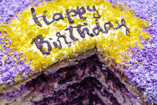 bolo com feliz aniversário de perto, com uma peça refletida e groselha preta dentro
 - Foto, Imagem