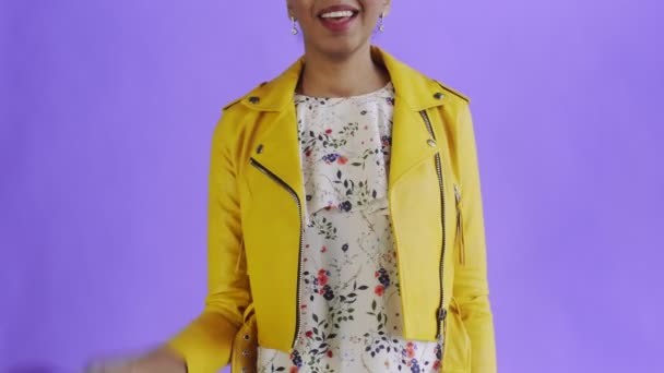 Satisfied african american woman with money is showing thumb up on purple background Yellow jacket - Πλάνα, βίντεο
