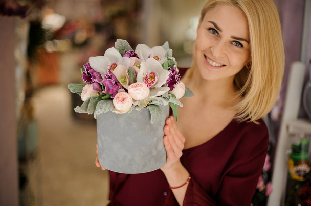 Girl holding box with irises, orchids and peonies - Foto, Imagem