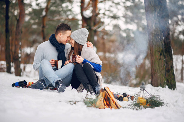 Cute and loving couple in a winter forest - Fotoğraf, Görsel