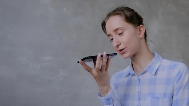 Woman holding smartphone and using voice recognition function - Materiał filmowy, wideo