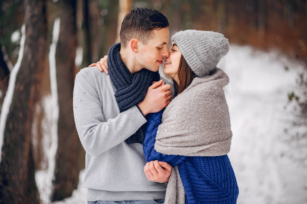 Cute and loving couple in a winter forest - Фото, зображення