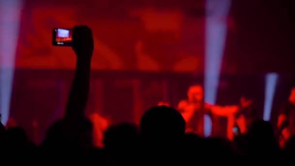 Spowolnienie ruchu: człowiek ręce nagrywania wideo koncertu muzyki na żywo ze smartfonem - Materiał filmowy, wideo