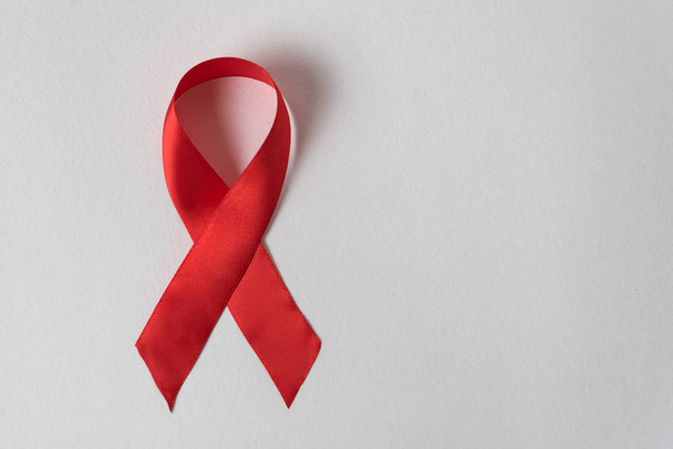Red ribbon on white background. Aid control symbol. Directly above - Foto, Bild