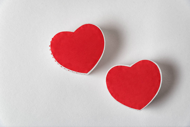 Twee rode hartvormige doosjes op de witte achtergrond. Begrepen, ruimte. Direct boven. Valentijnsdag - Foto, afbeelding
