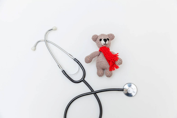 Просто мінімальний дизайн іграшкового ведмедя та медичного обладнання стетоскоп ізольований на білому тлі. Концепція охорони здоров'я дітей-лікарів. Символ педіатра. Плоский простір для копіювання зверху
 - Фото, зображення