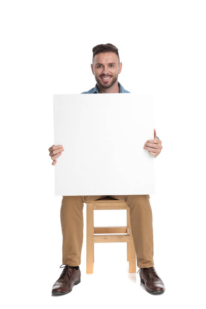 happy young casual man holding empty board - Photo, Image