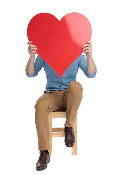 young casual man covering face with big red heart - Foto, immagini