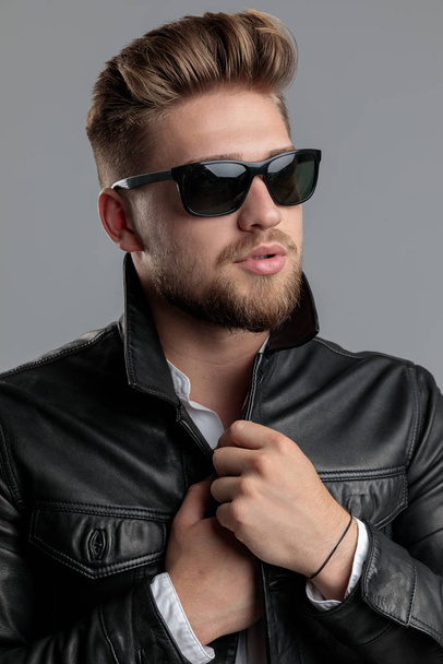 sexy young model wearing leather jacket and sunglasses - Foto, afbeelding
