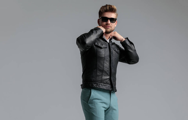 young handsome man wearing leather jacket and sunglasses - Photo, Image