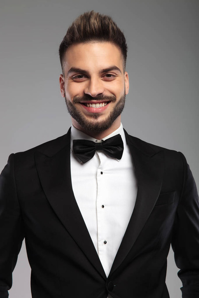 Cheerful groom smiling while wearing tuxedo - Photo, Image