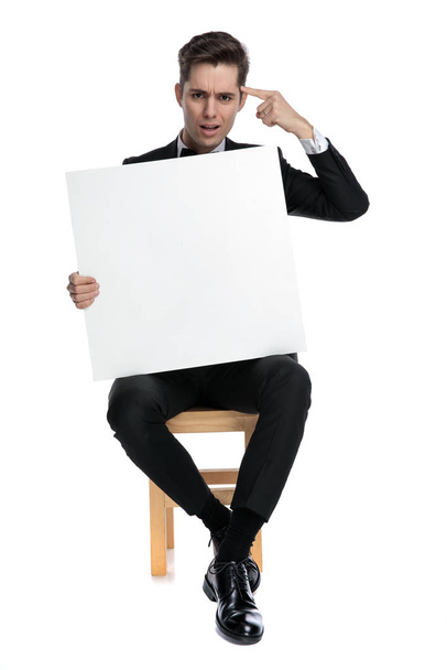 young model holding empty board and pointing finger to head - Photo, Image
