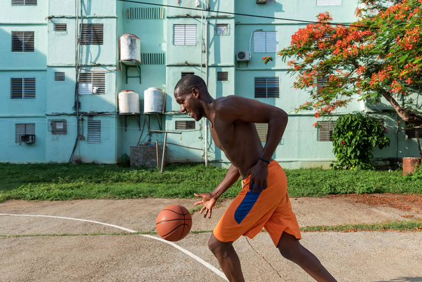Fiatal afro-amerikai férfi kosárlabdázik a szabadban bíróság Kubában - Fotó, kép