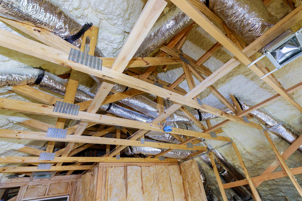 Dachboden-Dämmstoff wird mit flüssigem Schaum der Heizungsanlage auf das Dach gesprüht - Foto, Bild