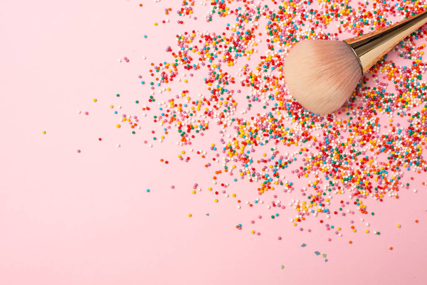 Makeup brush and multicolored round confetti with copyspace. Colorful beauty background. - Foto, imagen
