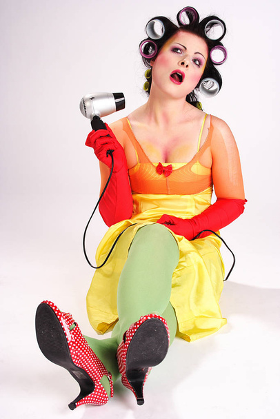 young woman in curlers with a hairdryer and a red hair - Foto, imagen