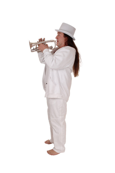 A trumpet player standing in a white outfit and hat - 写真・画像
