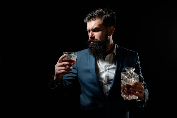 Whisky elegant. Man with beard holds glass of brandy. Bearded businessman in elegant suit with glass of whiskey. Luxury beverage concept. - Fotografie, Obrázek