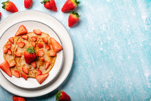 Pancakes with fresh strawberry on a blue wooden background - Photo, Image