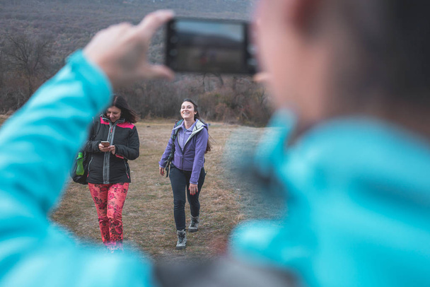 Female hikers taking photos with cell phone. Hiking, outdoors activity - Foto, Imagem