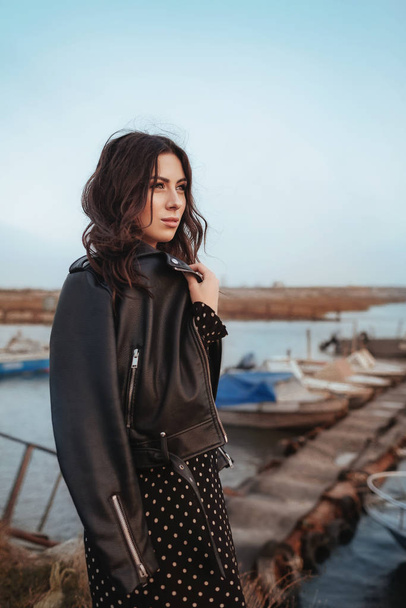  beautiful  young woman in dress and leather jacket - Фото, изображение