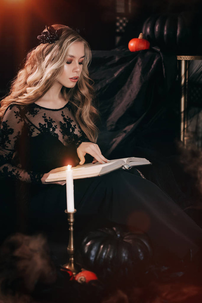Porträt der schönen blonden jungen Frau im schwarzen Kleid mit Buch - Foto, Bild