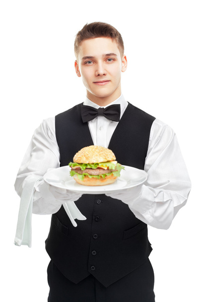 Young happy smiling waiter holding hamburger on plate - Foto, Imagen